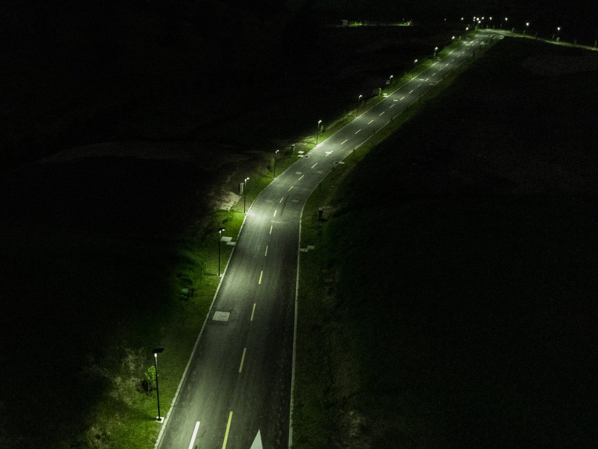 Vista aérea nocturna de una vía iluminada de extremo a extremo con luminarias solares GSS