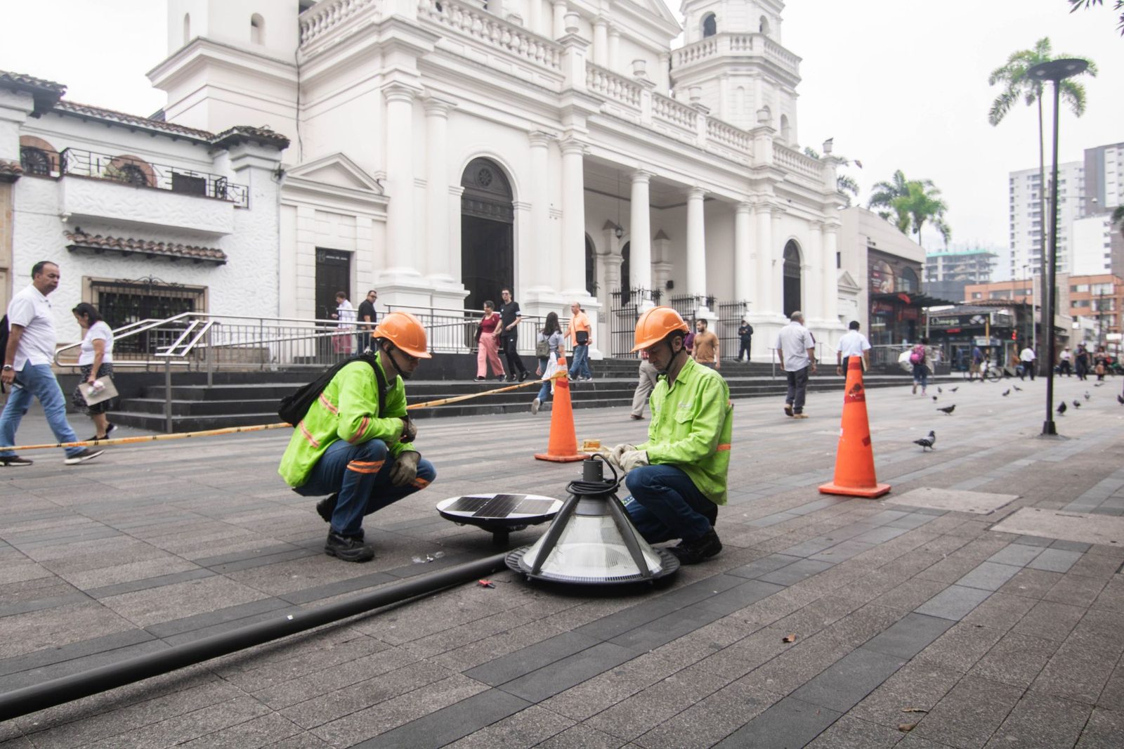 Dos técnicos de GSS ensamblando una luminaria solar en la plaza de un municipio